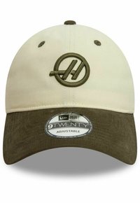 Beżowa i oliwkowozielona czapka z regulowanym paskiem, z okrągłym logo wyszytym w oliwkowym kolorze oraz teksturowanym, ciemnozielonym daszkiem.
