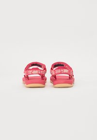 Rosa sandaler med justerbare stropper, med et teksturert stroppemønster og en lett gummisåle. Bakfra viser de et dobbelt stroppedesign.