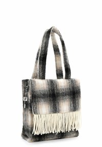 Bolso rectangular de cuadros en negro, gris y beige con dos correas y flecos blancos colgando debajo del cierre de solapa.