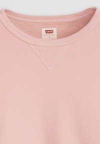Light pink sweatshirt with a round neck, ribbed trim, and a v-shaped stitching detail on the collar. Brand label visible inside.