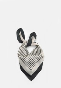 Hedvábný šátek s designem chevron, kde se střídají černé a bílé pruhy, svázaný nahoře, čímž vytváří hravou siluetu.