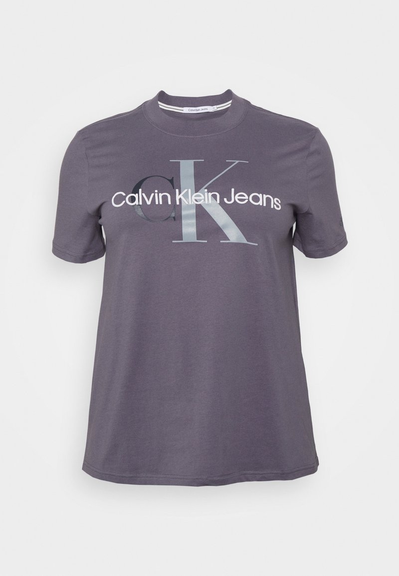 Camiseta de algodón gris con mangas cortas y cuello redondo, que presenta una gran impresión de "Calvin Klein Jeans" y un logotipo estilizado "CK" en colores contrastantes.