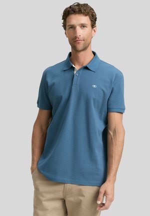 Blaues Poloshirt aus weichem Material, mit kragenförmigem Design, kurzen Ärmeln, zwei Knöpfen und einem kleinen Logo auf der linken Brust.