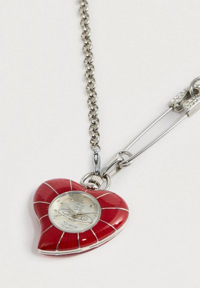 Südamekujuline ripats punases emailis, hõbedast detailidega, millel on metallikviimistlusega kellanägu ning nupumärgid, metallist ketil.