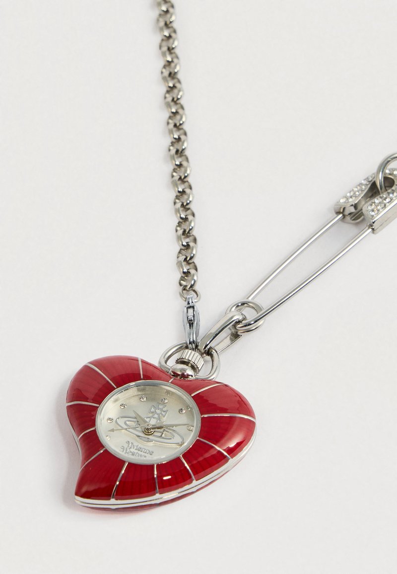 Hartvormige hanger in rood emaille, zilveren beslag, met een horloge met een metallic afwerking en gestileerde markers, aan een metalen ketting.