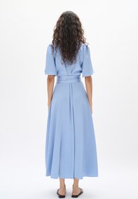 Helles blaues, knielanges Kleid mit kurzen Ärmeln, tailliertem Bund und fließendem Rock. Glatte Textur mit einem leichten Glanz.