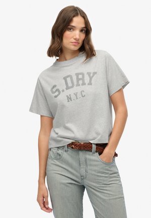 Grå bomulds T-shirt med korte ærmer og rund hals, med en mørkegrå tryk "S.DRY N.Y.C." henover brystet. Bæres med stribede jeans.