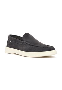 Zapatos slip-on de ante gris con suela de goma crema, que presentan detalles de costura y una textura suave, diseñados para facilitar su uso.