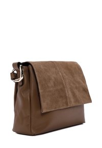 Sac à main en cuir marron et en daim avec un rabat supérieur plat, une surface texturée et un détail de boucle métallique sur la bandoulière.