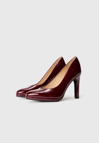 Escarpins en cuir verni bourgogne avec un élégant bout pointu, une finition lisse et brillante, et un talon aiguille effilé.