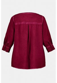 Blouse bordeaux à manches longues avec un motif texturé, poignets boutonnés et un détail de pli au dos, fabriquée en tissu lisse.