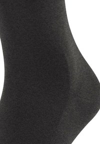 Donkergrijze sokken gemaakt van een glad, rekbaar materiaal. Het ontwerp heeft een subtiele geribde textuur en verstevigde tenen en hielen.