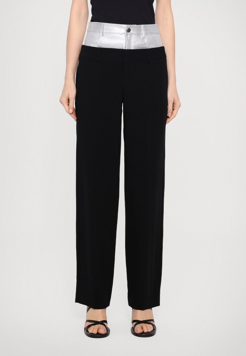 Zwarte broek met een glanzende zilveren tailleband en knoopsluiting. Heeft een wijde pijpontwerp en is gemaakt van een gladde stof.