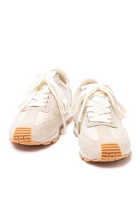 Sneaker beige in suede e mesh, con punta rotonda, lacci piatti e suole in gomma con accenti arancioni.