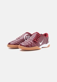 Burgundijas sporta apavi ar quilted sintētisko augšdaļu, gumijas zoli un baltām akcentiem, ar saitēm un mīkstinātu apkakli.