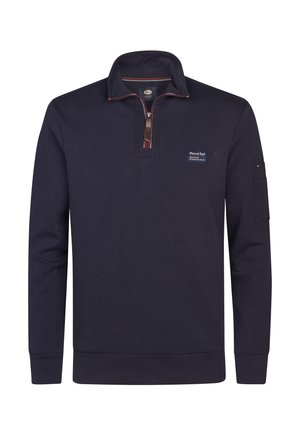 Sudadera de corte corto en color azul marino, hecha de una tela suave, que presenta un parche de la marca en el pecho y un bolsillo lateral con cremallera.