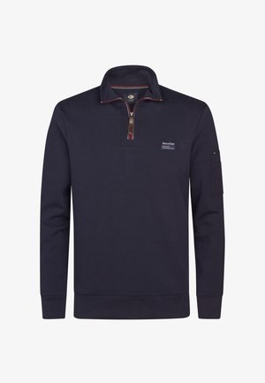 Sudadera de corte corto en color azul marino, hecha de una tela suave, que presenta un parche de la marca en el pecho y un bolsillo lateral con cremallera.