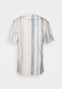 Camiseta de manga corta en tejido ligero. Presenta rayas verticales en tonos crema, beige y azul suave. Cuello redondo y corte relajado.