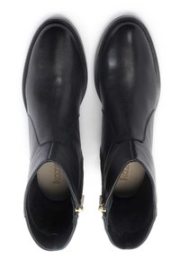 Bottes chevilles en cuir noir à texture lisse, bout arrondi et fermetures éclair latérales. Présentent des coutures minimales et une silhouette élégante.