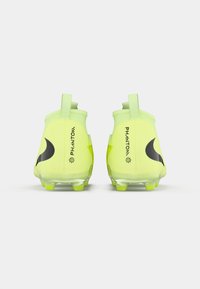 O pereche de ghete de fotbal neon galben cu logo-uri negre în formă de swoosh și textul "PHANTOM", văzute din spate pe un fundal alb.