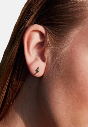 Guldtonet lynbolt stud ørering med et slankt, geometrisk design. Struktureret overflade med en poleret finish. Bæres i øret.