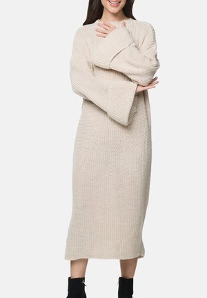 Langes, beige gestricktes Kleid mit lockerer Passform, weiten Ärmeln und angenehmer, gerippter Struktur, das bis zur Mitte der Wade reicht.