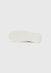 Talpa de pantof din cauciuc alb, având o suprafață texturată cu un model în grilaj pentru aderență și stabilitate. Design cu vârf plat și rotund.