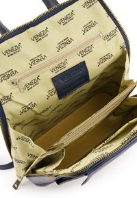 Granatowa torebka skórzana w środku z beżową podszewką z logo "Venezia". Zawiera kieszeń na zamek oraz dwie komory o beżowej fakturze.
