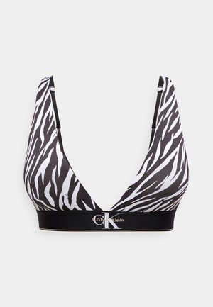 Black and white zebra-print bralette with adjustable straps and Calvin Klein logo band at the bottom.