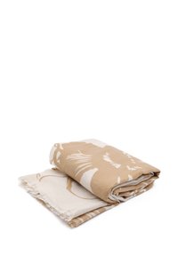 Coperta beige e bianca a motivi con bordi frangiati, caratterizzata da disegni floreali astratti su un tessuto morbido, arrotolata per una facile conservazione.