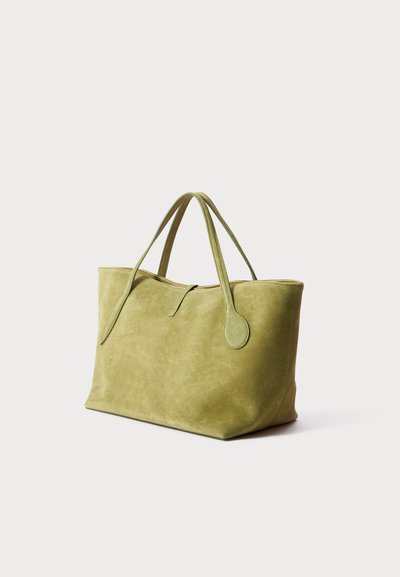 Geantă tote din suede verde, cu două mânere superioare, închidere cu fermoar și textură netedă. Formă rectangulară cu colțuri rotunjite.