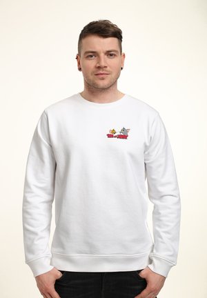 Hvid sweatshirt med et broderet grafisk motiv af Tom og Jerry på brystet. Ribkant på ærmer og nederkant, blødt bomuldsstof, afslappet pasform.