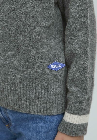 Šedý vlnený sveter s rebrovanými manžetami, s modrou diamantovou nášivkou označenou "BALL" na prednej strane a kontrastnými bielymi pruhmi na rukávoch.