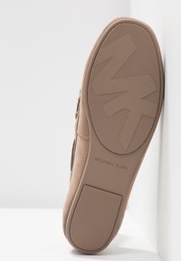 Baskets en daim camel avec une semelle en caoutchouc contrastante, arborant un logo "MK" embossé, une surface texturée pour l'adhérence, et des accents de couture minimalistes.