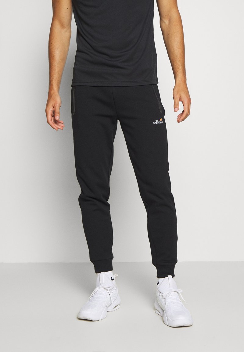 Černé bavlněné joggery se zúženým střihem, obsahující boční kapsy, elastický pas a vyšívané logo na přední straně.