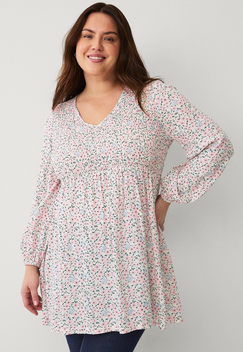 Bloemenprint top met een V-hals, lange ballonmouwen, en geplooide textuur, met roze, groene en blauwe kleuren op een lichte achtergrond.