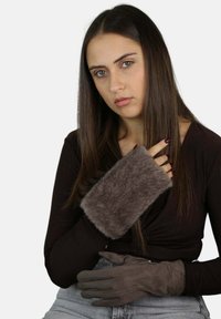 Guantes marrones de piel sintética con una textura suave y un diseño ajustado. La capa exterior es lisa, complementando la silueta de la mano.