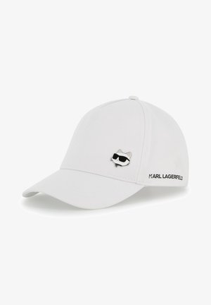 Casquette de baseball blanche avec une visière courbée, ornée d'une épingle représentant un chat noir et blanc. "KARL LAGERFELD" est brodé sur le côté en noir.