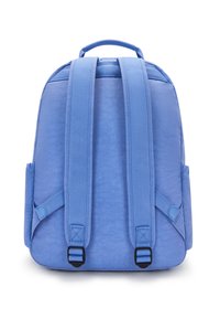 Blå ryggsäck sedd bakifrån med vadderade justerbara axelremmar och handtag upptill mot en vit bakgrund.