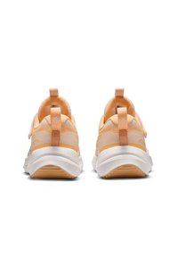 Zapatillas deportivas de color naranja claro con parte superior de malla, talón acolchado y suela blanca. Cuenta con una lengüeta en el talón en forma de lazo para facilitar su uso.