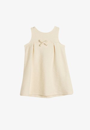 Jasno beżowa sukienka bez rękawów z teksturowanej tkaniny, okrągłym dekoltem i małym detalem w postaci kokardy z przodu. Rozkloszowany fason w kształcie litery A.