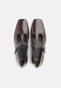 Rudi lakinės odos batai su kvadratiniu priekiu, šoninėmis išpjovomis ir reguliuojamu dirželiu su sidabrine sagtimi.