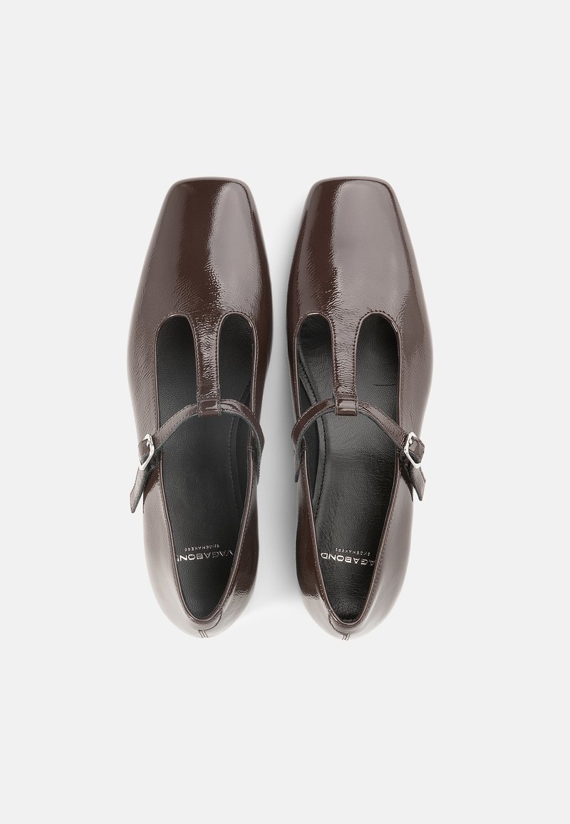 Brown patent leather shoes with a square toe, cutouts on the sides, and an adjustable strap featuring a silver buckle.