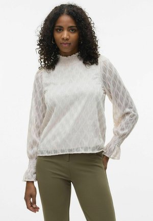 Witte langemouwenblouse met een textuur van golfpatroon, hoge smockhals, en geplooide manchetten, gecombineerd met olijfgroene broek.