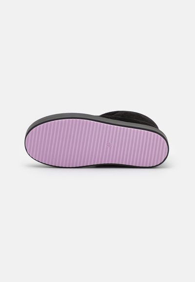Zapato de gamuza negra con una suela de goma morada texturizada y un borde negro. La parte inferior presenta surcos horizontales para mejorar la tracción.