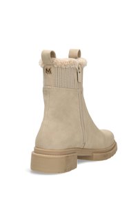 Beige ankelboot med en slät faux mockakvalitet, ribbat tyg runt kragen, faux pälsfoder och en kraftig gummisula.