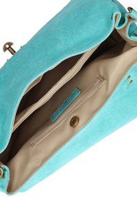 Turquoise suède tas met een beige stoffen binnenkant, voorzien van een ritszak en een messing hardware sluiting. Zachte textuur en ruim ontwerp.