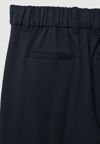 Dunkelblaue Hose mit elastischem Bund, Gürtelschlaufen und zwei horizontalen Gesäßtaschen auf einfarbigem Hintergrund.