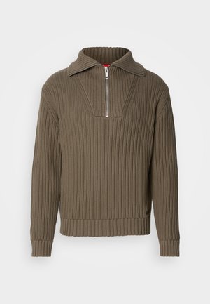 Brun ribbestrikket genser med halv glidelås og bred krage. Har et teksturert stoff og en litt cropped kant. Enkel design.