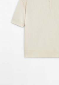 Gebreide trui in gebroken wit met korte mouwen, geribbelde manchetten en zoom, voorzien van een kraag met drie knoopjes.